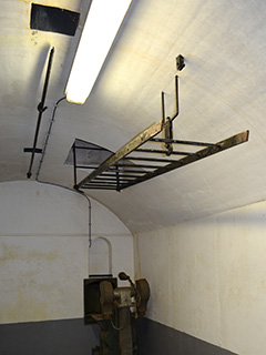 Een binnenopname met de ladder naar de observatiekoepel opgehangen en vastgeklikt op fort Kudelstaart.