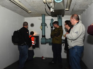 Bezoekers bj de nooduitgang en ventilator.
