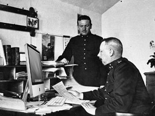 De commandant van Fort bij Nigtevecht leest een nieuwsbrief.