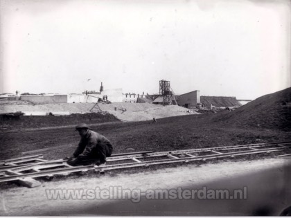 Arbeider legt smalspoor aan op Fort bij Spijkerboor.