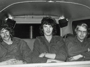 Een drietal soldaten achterin een Volkswagen Combi.