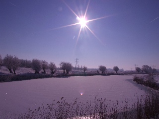 Tegenlicht boven een besneeuwde St. Aagtendijk bij Fort bij Veldhuis.