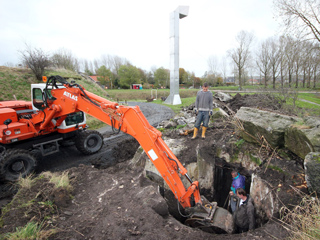 Shovel met grijper aan het werk bij hefkoepelgebouw Fort bij Vijfhuizen.