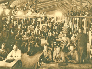 Interieur barak met soldaten in barakkenkamp Halfweg.