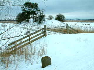 Besneeuwde kazemat Keverdijk met grenspaal.