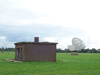 Een van de gebouwen met een paraboolantenne virtueel op een sokkel.