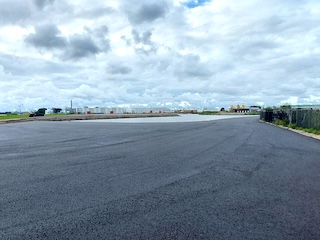 Asfaltvlakte op Fort bij Velsen, gezien vanaf de dijk van het Noordzeekanaal.