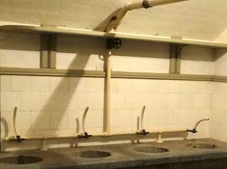 Leidingen, kranen en bladen in een waslokaal in de bomvrije kazerne van Fort Waver-Amstel.