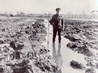 Een Britse militair met meetlat in het weer leeggepompte inundatieterrein bij Spaarndam.