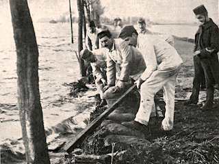 Militairen versterken een dijk tijdens de watersnoodramp 1916.